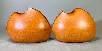 deux vases en bois posés l'un à côté de l'autre sur une table