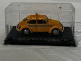 a yellow toy car in a clear case