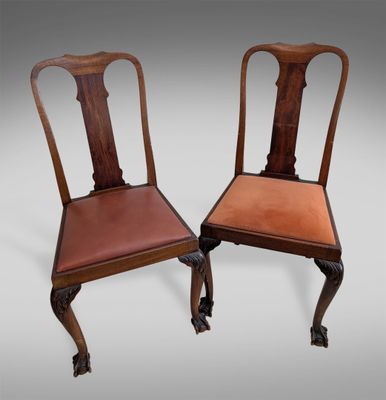 une paire de chaises anciennes en acajou avec des assises rembourrées de cuir