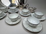 a lot of cups and saucers sitting on a table