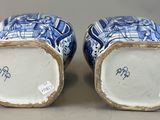 pair of chinese blue and white vases on display on a table