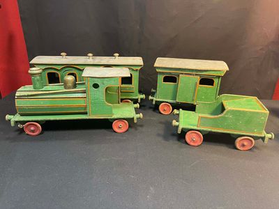 two green toy trains sitting next to each other on a table