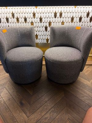 deux chaises grises posées sur un parquet, près d'un mur
