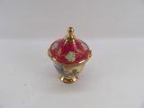 an image of a red and gold vase with a bird on it