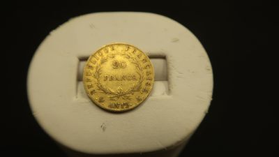 une image représentant une pièce d'or posée sur un objet blanc
