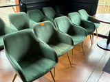 Plusieurs chaises vertes sont alignées en rang devant une fenêtre
