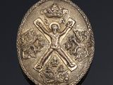 an image of a gold medal with a crown and cross on it