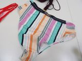 a striped bikini with a red bag on the floor