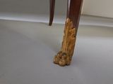 a close up of a wooden table with a carved leg