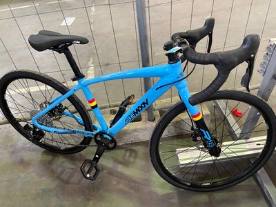 un vélo bleu garé devant une clôture