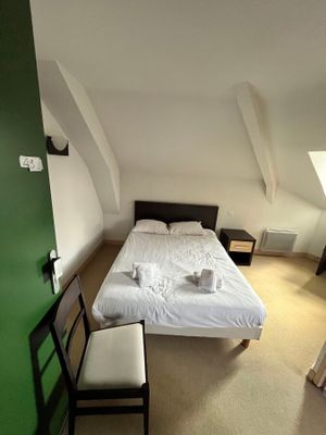 une chambre avec un lit et une chaise