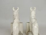 two figurines of cats sitting on top of each other