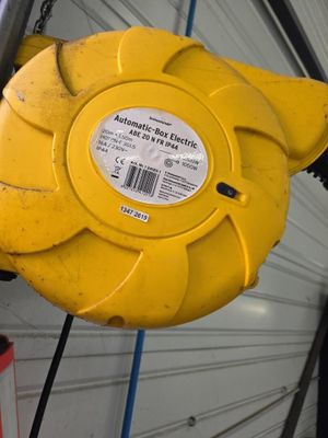 une borne d'incendie jaune fixée sur le mur d'un immeuble