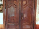 a large wooden cabinet with a mirror on top of it