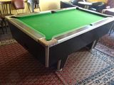 a pool table in the middle of a room with chairs