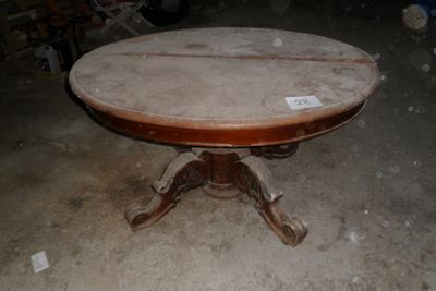 une table ronde avec un plateau en bois dans une pièce
