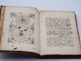 un livre ouvert avec une écriture dessus, posé sur une table