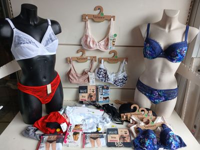 deux mannequins exposés devant un présentoir de combinaisons en dentelle