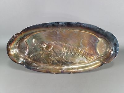 une assiette en argent sur laquelle est représenté un homme et une femme