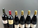six bottles of wine are lined up in a row on a table