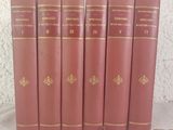 six livres rouges sont alignés sur une table