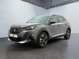 un SUV gris garé dans une grande pièce aux murs blancs