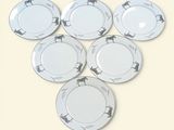 six white plates with horses on them sitting on a table