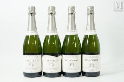 quatre bouteilles de champagne sont alignées sur une surface blanche