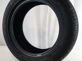 a close up of a tire on a white surface with a curtain in the background