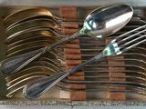 a lot of silver spoons and spoons in a box