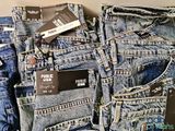 several pairs of men ' s jeans are stacked on top of each other