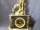 une statue représentant une femme tenant un chien et une horloge