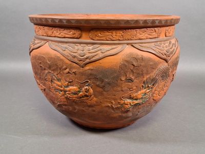 a large brown vase with a dragon design on it