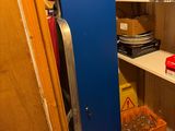 a blue locker in the corner of a room filled with items