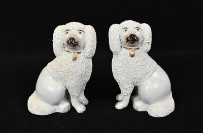 une paire de figurines de caniches en céramique blanche sur fond noir