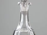 a clear glass decanter with a silver handle on a table