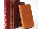 three books are stacked on top of each other on a white surface