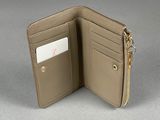 beige leather wallet with zipper and card holder on grey surface