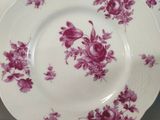 three plates with pink flowers on them on a table