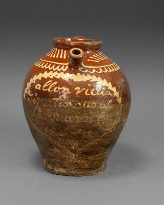 a brown and white vase sitting on a gray surface