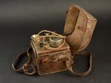 a brown leather case with a compass on top of it