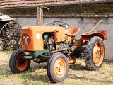 un vieux tracteur qui est à l'abandon dans l'herbe