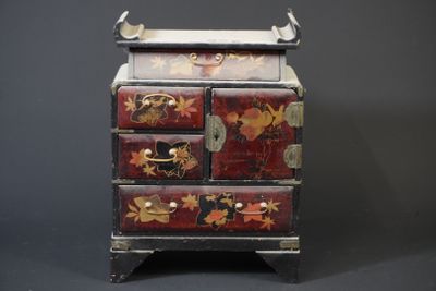 a small wooden chest of drawers with flowers and leaves on it
