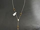 un collier en argent et en or sur un fond noir, orné d'une médaille