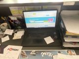 a laptop computer sitting on top of a desk covered in papers