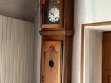 une horloge de parquet qui se trouve dans un coin de la pièce