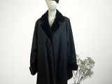 un mannequin vêtu d'un manteau noir et d'un chapeau