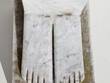 a white marble sculpture of a foot on a pedestal