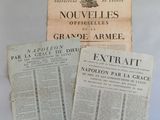 three old french newspapers sitting on top of a white table
