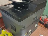 a man standing in front of a printer on a table